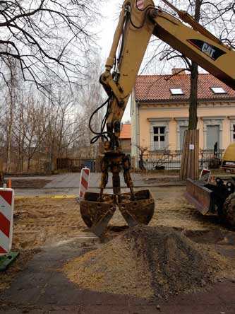 Foto von Bagger, der vor die Einfahrt einen Sandhaufen macht - heute