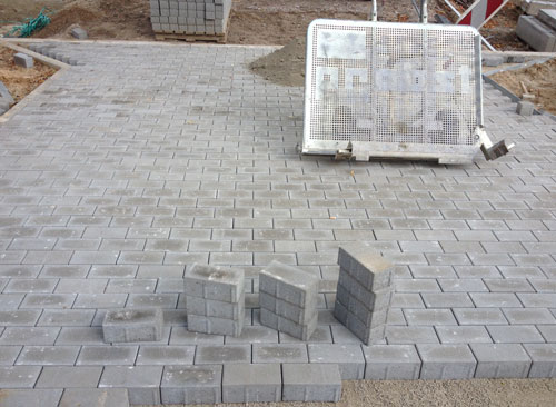 Einfahrt - neu Foto von einer Einfahrt, die mit Betonsteinen ausgelegt wurde, ist zu sehen.