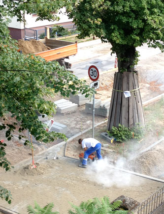 schneiden Foto von einem Tiefbauer, der Betonsteine schneidet, ist zu sehen.