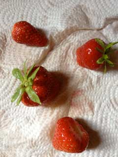 Foto von Erdbeeren auf Papier liegend.
