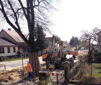 Foto von einem Bagger, der Graben zuschüttet.