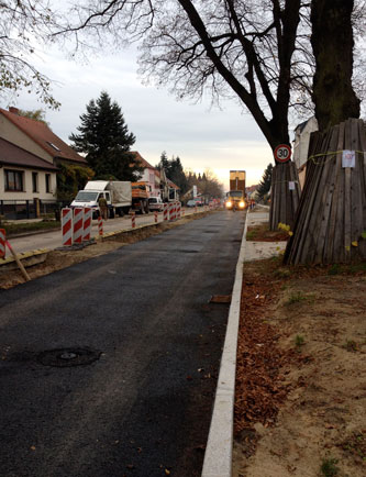 Foto von großem LKW, der Asphalt abkippt- heute.