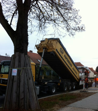 Foto von großem LKW, der Asphalt abkippt- heute.