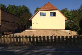 Foto von dem neuen Einfamilienhaus aus Beton in der Straße ist zu sehen - heute.