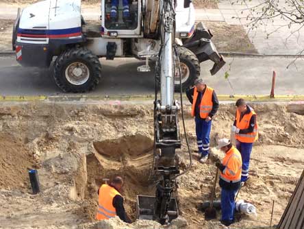 Foto von Tiefbauern vor dem Baggerloch in der Einbahnstraße.