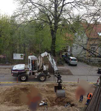 Foto: auf der Straßenbaustelle wird vor dem Grundstück wird der Schacht eingemessen