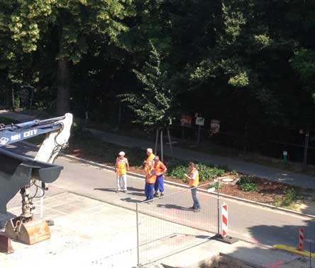 Foto von einer Gruppe von Männern, die vor dem Bagger stehen