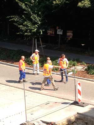 Foto von einer Gruppe von Männern, die vor dem Bagger stehen