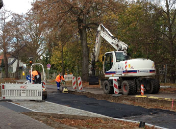 Foto von Walze  und Bagger u. a. auf der Baustraße - heute.