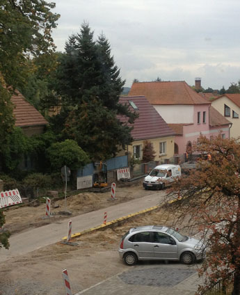 Blick auf das Grundstück Nr. 84 heute Foto von der anderen Straßenseite mit Graben - Grundstück Nr. 84 ist zu sehen.