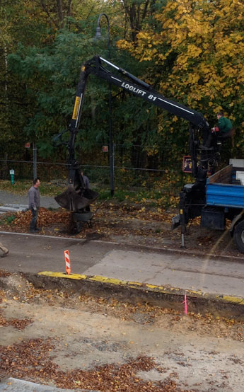 Foto von Männern mit Schubkarren - neben der Linde 74 - steht ein großer LKW - Foto.