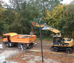 Bagger und Eurovia von Eurovia. Vor dem Haus Bagger und LKW der Firma Eurovia - Foto.