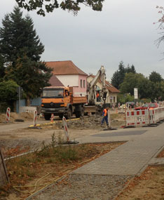 Blick auf Bagger heute Foto von einem Bagger und LKW vor der zweiten Parktasche ist zu sehen.