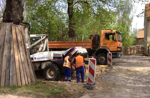 Foto von Bagger und LKW direkt vor der Einfahrt.