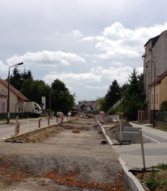 Foto von Bagger und LKW in der Straße ist zu sehen.