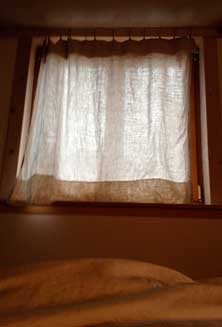 Foto von einem Fenster mit vorgezogenem Vorhang am Tag