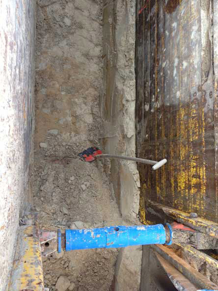 Foto: Blick in die Grube, wo die neue Druckleitung liegt, mit einem Laserpunkt