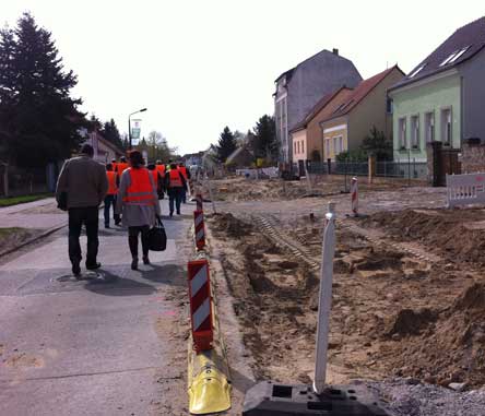 Foto von der Baustellenstraße mit vielen Menschen mit roten Westen.