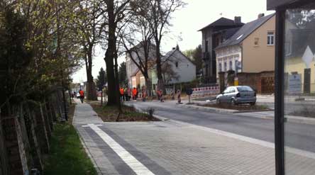 Foto von der Baustellenstraße mit vielen Menschen mit roten Westen.