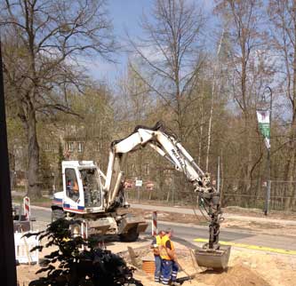 hier: Tiefbauarbeiter und Bagger vor Haus mit Nr. 133 Foto von Bagger mit Tiefbauer vor Hausnr. 133.