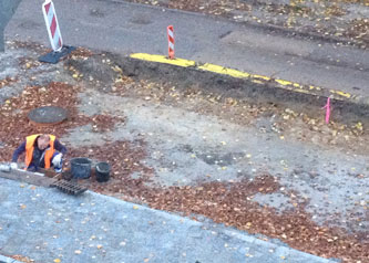 Euroviamitarbeiter an Einlauf. Vor dem Haus wird an einem Einlauf gearbeitet - Foto.
