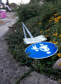 Blick auf Sträucher und Schild am Marienweg heute Foto von einem Straßenschild, welches auf Anpflanzung geworfen wurde, ist zu sehen.