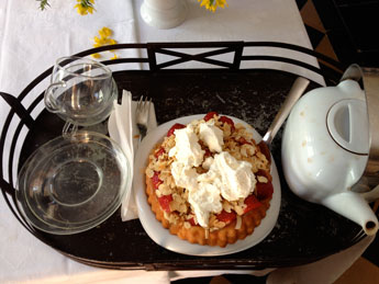 Foto von einem Tablett mit Teetassen und Kuchen.