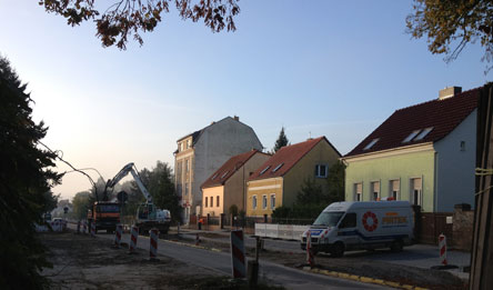 Foto von der Eisenbahnstraße in Höhe Hausnr. 83 mit Bagger und LKW ist zu sehen.