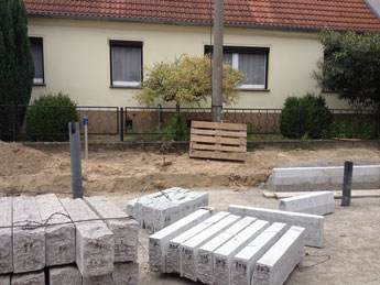 Granitborde in der Straße Foto von Granitborden und Häusern ist zu sehen.