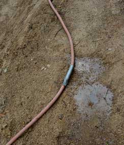 Foto von einem dünnen Wasserschlauch, der geflickt ist im Baustellenbereich an der Hausnummer 133 direkt vor dem Tor. title=