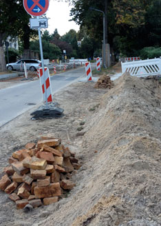 Foto von einem Graben, daneben liegen Steine, ist zu sehen.