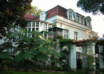 Foto von großer Villa mit Pergola ist zu sehen.