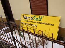 Foto von der Straße auf ein Wrbeschild für Fertighäuser