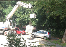 Wasserbehälterabtansport Foto mit einem Wasserbehälter auf der Straße, der abgeholt wird, ist zu sehen.